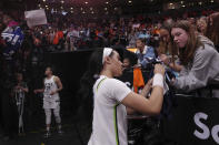 Minnesota Lynx's Brea Beal, right, signs autographs for fans after a preseason WNBA basketball game against the Chicago Sky in Toronto, Saturday May 13, 2023. (Chris Young/The Canadian Press via AP)