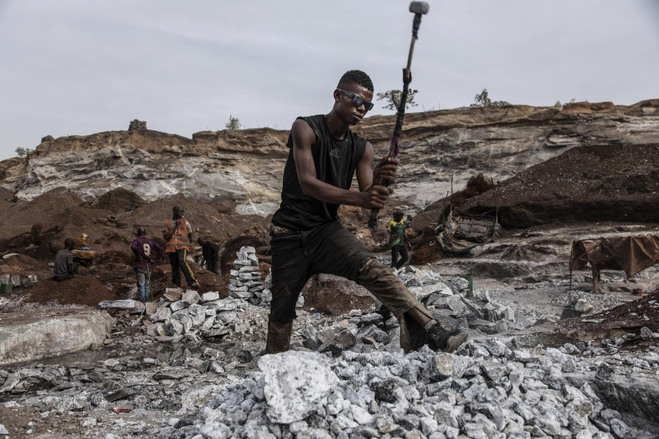 Men work in a Pissy granite mine in Ouagadougou, Burkina Faso, Monday April 25, 2022. The influx of people displaced by the country's rapidly rising Islamic violence is causing competition among the approximately 3,000 people working at the granite mine. At least 500 displaced people started working at the mine last year making it harder for the original miners to earn a living, said Abiba Tiemtore, head of the site. (AP Photo/Sophie Garcia)