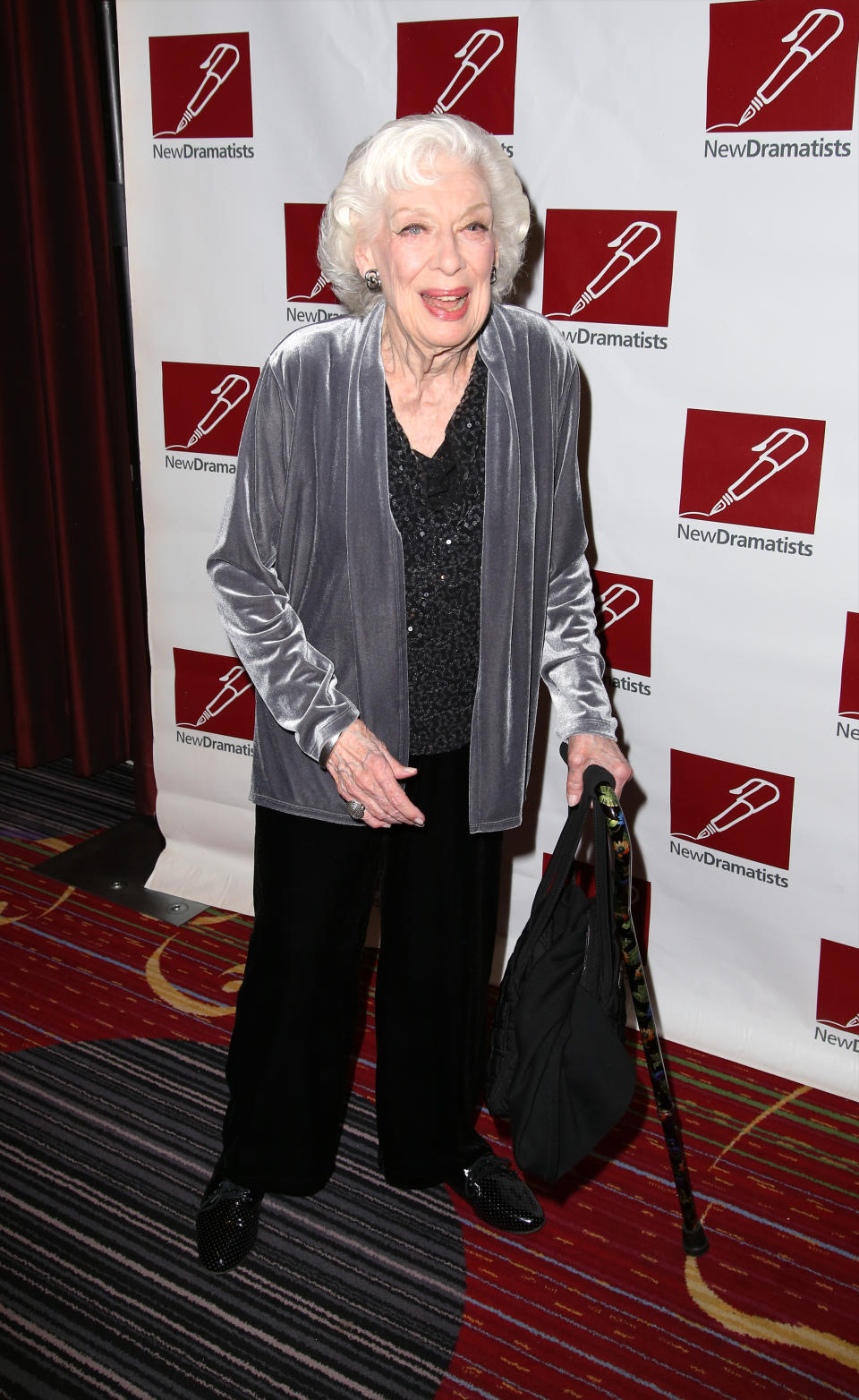 Joyce Randolph on red carpet with a cane