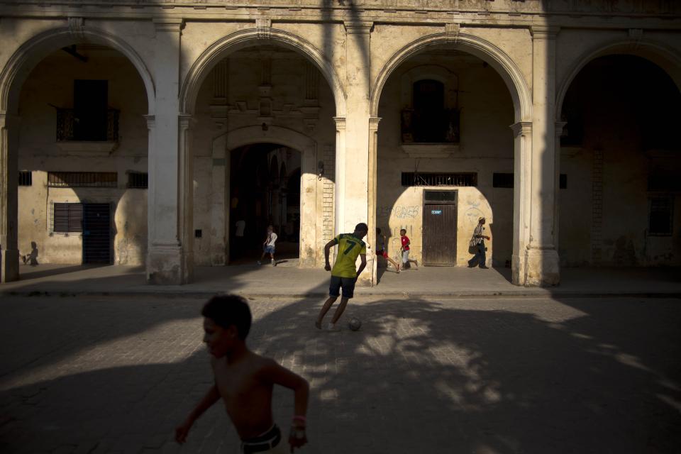 In this April 12, 2014 photo, children play soccer near a colonial building in Havana, Cuba. When President Raul Castro legalized a real estate market for the first time in five decades, it was expected to stimulate both new construction and maintenance of existing homes. But 2 ½ years later, there's only been a minimal impact on easing one of Cuba's biggest challenges: a chronic lack of suitable housing. (AP Photo/Ramon Espinosa)