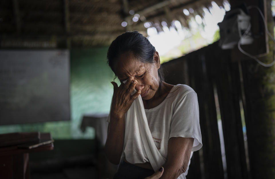 Murui woman Zoila Ochoa Garay cries as she tells a member of the OnePlanet NGO team about the threats her family has received from land invaders that she believes is due to the construction of a new federal highway that crosses their communal territories, in Nuevo Arenal, Peru, Tuesday, May 28, 2024. (AP Photo/Rodrigo Abd)