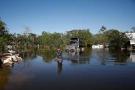 FILE PHOTO: A man walks in a flooded field after Hurricane Delta, in Lake Charles
