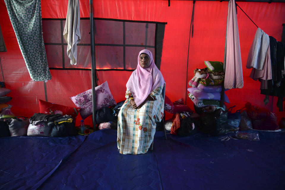 Fatima Khatun, a Rohingya survivor of a capsized refugee boat, poses for a photograph inside her tent in Meulaboh, Indonesia, on Thursday, April 4, 2024. Fatima was among 75 people rescued in March from atop the overturned hull of the boat. Dozens of others, including Fatima's 8-year-old daughter, died. (AP Photo/Reza Saifullah)