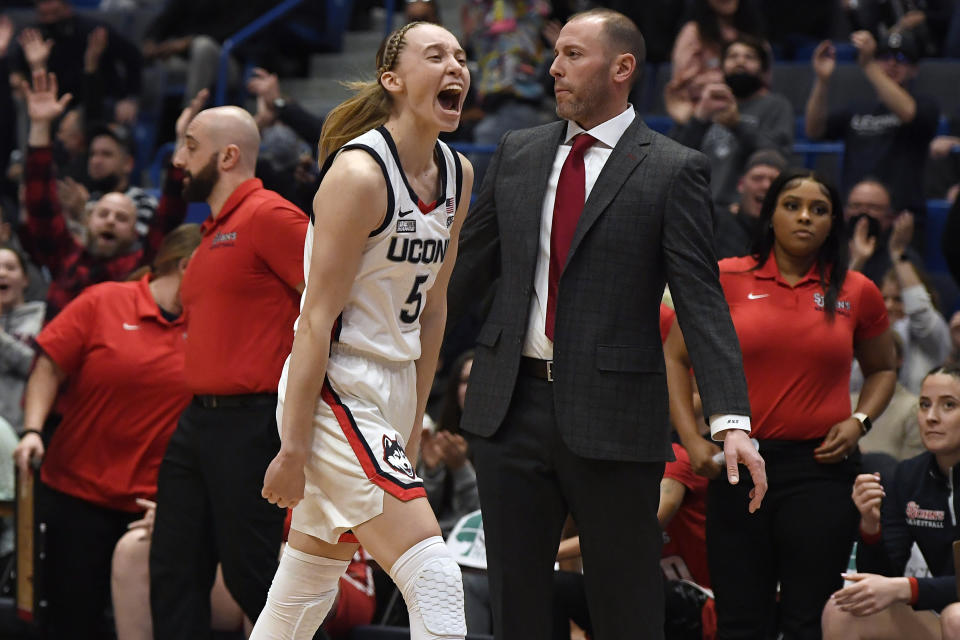 Connecticut's Paige Bueckers, left, reacts after making her first basket after coming back from being injured, in the first half of an NCAA college basketball game against St. John's, Friday, Feb. 25, 2022, in Hartford, Conn. (AP Photo/Jessica Hill)