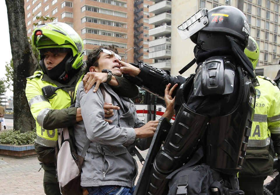 In this Sept. 6, 2018 photo, police detain a man who was blocking traffic during a protest against a decree by Colombia's President Ivan Duque that would allow police to confiscate any amount of drugs from people in the street in Bogota, Colombia. In 2012, Colombia's Constitutional Court approved a government bill to decriminalize the possession of small quantities of drugs for personal use. (AP Photo/Fernando Vergara)