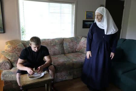 California "weed nun" Christine Meeusen, 57, who goes by the name Sister Kate (R), talks to her son Alex as he eats lunch at Sisters of the Valley near Merced, California, U.S., April 18, 2017. REUTERS/Lucy Nicholson