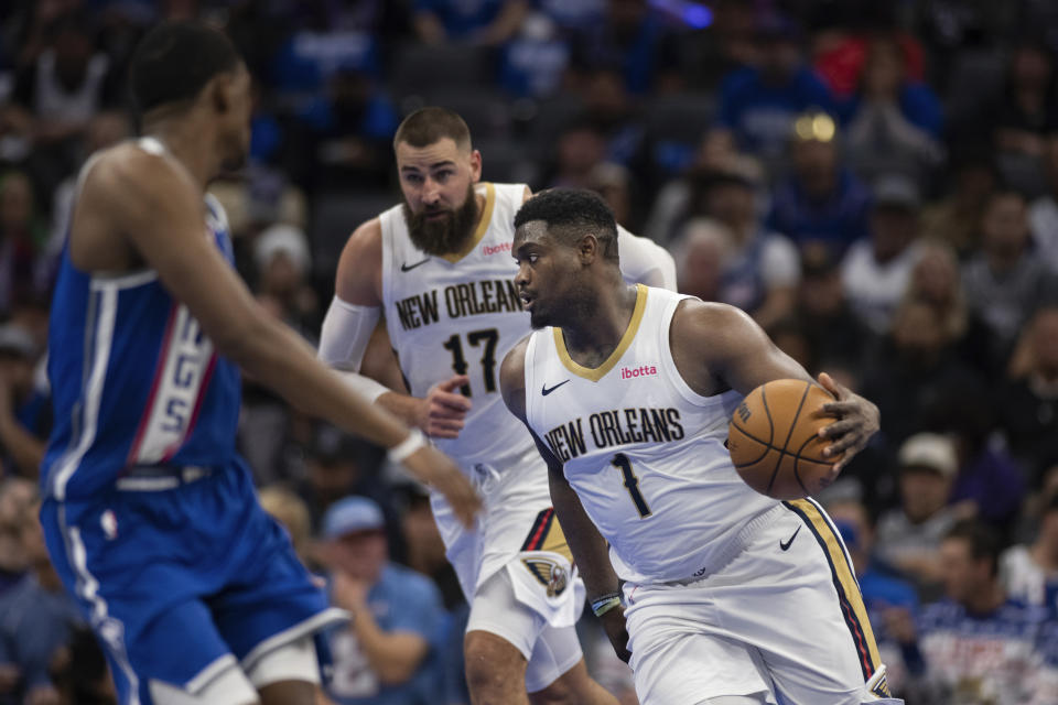 New Orleans Pelicans center Jonas Valanciunas (17) follows forward Zion Williamson (1) as he starts a fast break as Sacramento Kings guard De'Aaron Fox, left, prepares to defend in the second half of an NBA basketball game in Sacramento, Calif., Monday, Dec. 4, 2023. The Pelicans won 127-117. (AP Photo/José Luis Villegas)