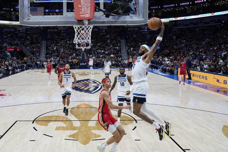 Minnesota Timberwolves guard Nickeil Alexander-Walker (9) goes to the basket to slam dunk over New Orleans Pelicans guard Dyson Daniels in the first half of an NBA basketball game in New Orleans, Monday, Dec. 11, 2023. (AP Photo/Gerald Herbert)