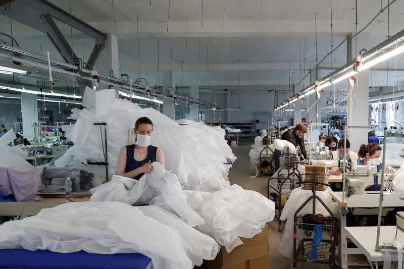 An employee checks protective suits at the Textile-Contact company's factory in Chernihiv