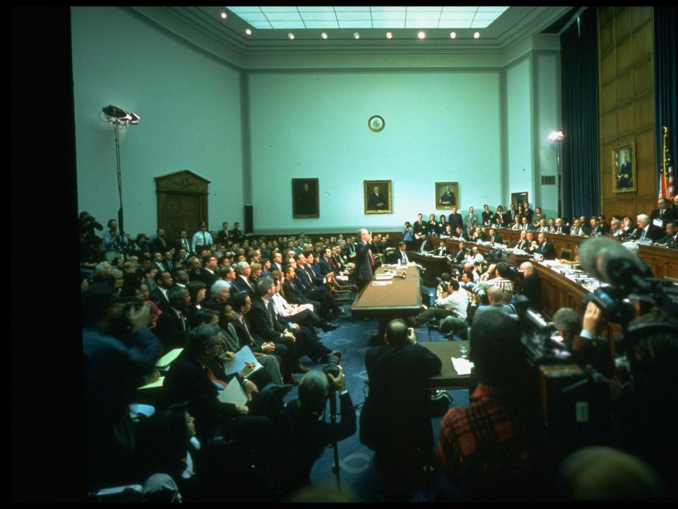 Independent counsel Ken Starr (C) raising hand, swearing-in before House Judiciary Committee, testifying in impeachment inquiry against Pres. Clinton in Capitol Hill committee room panorama.