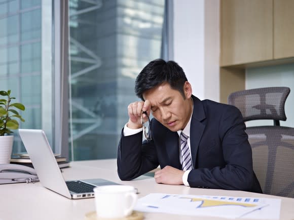 Business man near computer thinking hard