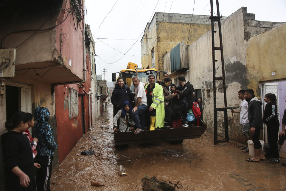 People are rescued during floods after heavy rains in Sanliurfa, Turkey, Wednesday, March 15, 2023. Floods caused by torrential rains hit two provinces that were devastated by last month's earthquake, killing at least 10 people and increasing the misery for thousands who were left homeless, officials and media reports said Wednesday. At least five other people were reported missing. (Hakan Akgun/DIA via AP)