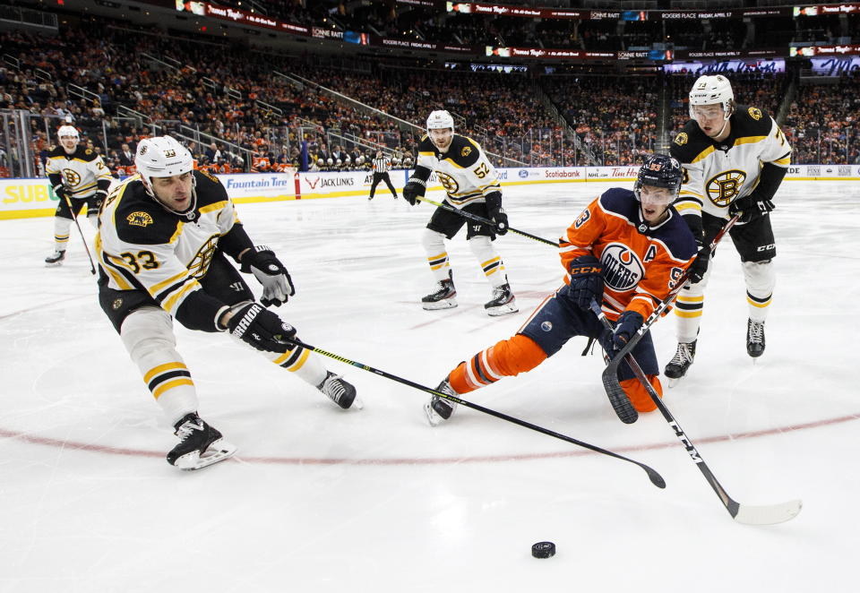 Boston Bruins defenseman Zdeno Chara (33) and teammate defenseman Charlie McAvoy (73) battle for the puck with Edmonton Oilers' Ryan Nugent-Hopkins (93) during the second period of an NHL hockey game, Wednesday, Feb. 19, 2020 in Edmonton, Alberta. (Jason Franson/The Canadian Press via AP)