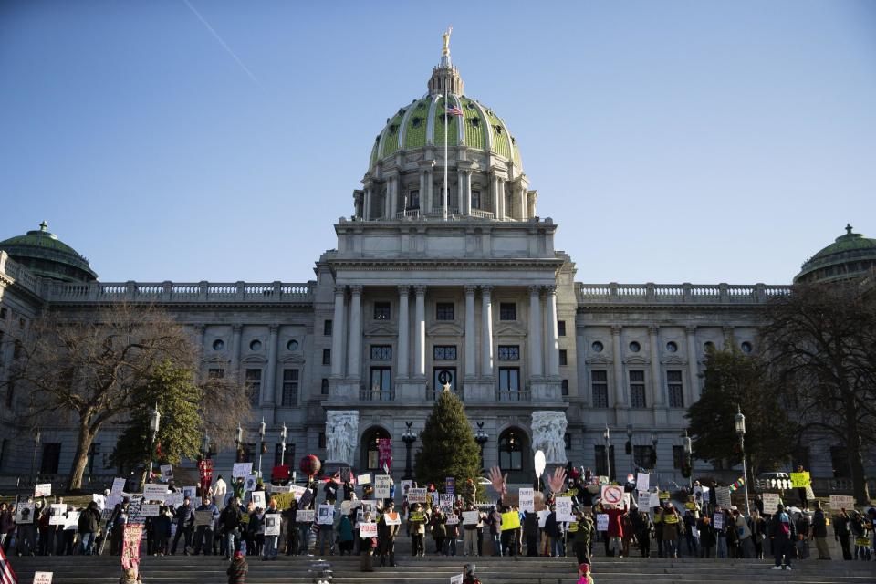 Protesters demonstrate ahead of Pennsylvania's 58th Electoral College at the state Capitol in Harrisburg, Pa., Monday, Dec. 19, 2016. The demonstrators were waving signs and chanting in freezing temperatures Monday morning as delegates began arriving at the state Capitol to cast the state's electoral votes for president. (AP Photo/Matt Rourke)