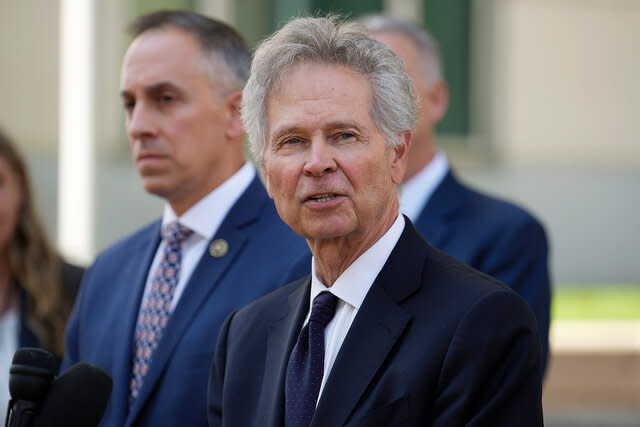 U.S. Attorney for Colorado, Cole Finegan, front, speaks as Mark Michalek, special agent in charge of the FBI bureau in Denver, back, looks on.