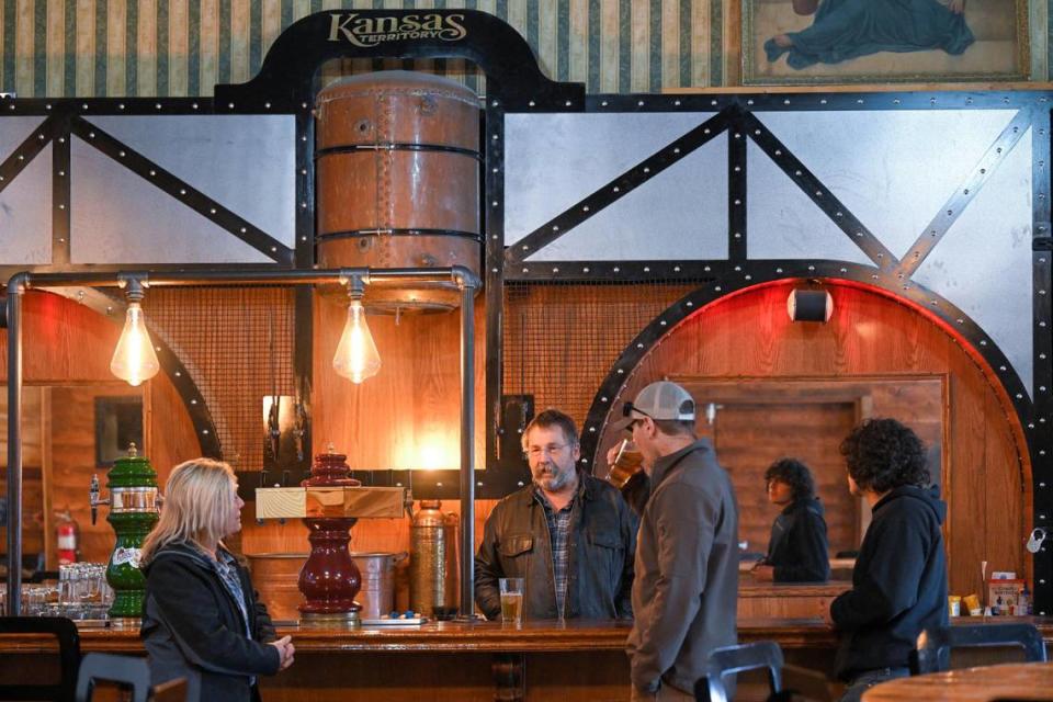 Donna and Brad Portenier, owners of Kansas Territory Brewing Co., talk with Devon Santorno and Caidan White, right, who stopped in on a visit from Colorado in March to sample some beers.