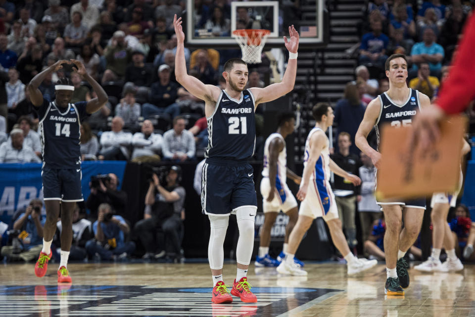 Samford guard Rylan Jones (21) gestures to the crowd as a timeout is called during the second half of the team's first-round college basketball game against Kansas in the men's NCAA Tournament in Salt Lake City, Thursday, March 21, 2024. (AP Photo/Isaac Hale)