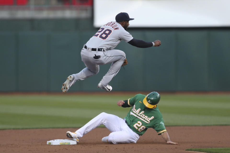 Oakland Athletics' Matt Olson, right, slides into second as Detroit Tigers' Niko Goodrum throws to first on a ball hit by Matt Chapman, who was safe during the second inning of a baseball game in Oakland, Calif., Friday, April 16, 2021. (AP Photo/Jed Jacobsohn)