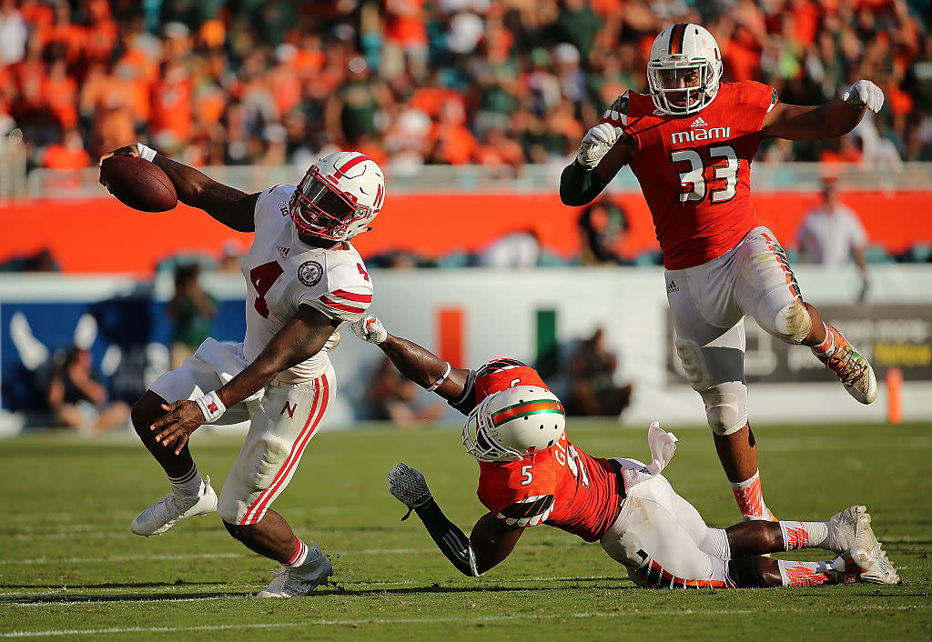 MIAMI GARDENS, FL - SEPTEMBER 19: Tommy Armstrong Jr. #4 of the Nebraska Cornhuskers is pressured by Jermaine Grace #5 of the Miami Hurricanes during a game at Sun Life Stadium on September 19, 2015 in Miami Gardens, Florida. (Photo by Mike Ehrmann/Getty Images)