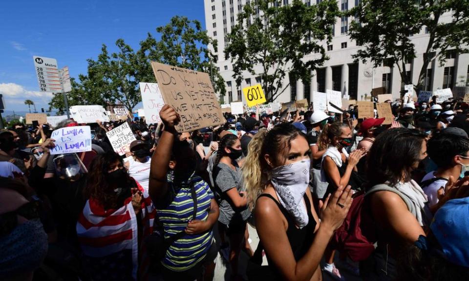 Demonstrators hold signs in front of the district attorney’s office protesting the death of George Floyd, in Los Angeles.