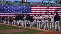 Baltimore Orioles players stand for the national anthem prior to the opening day baseball game against the Boston Red Sox, Thursday, March 30, 2023, in Boston. (AP Photo/Charles Krupa)