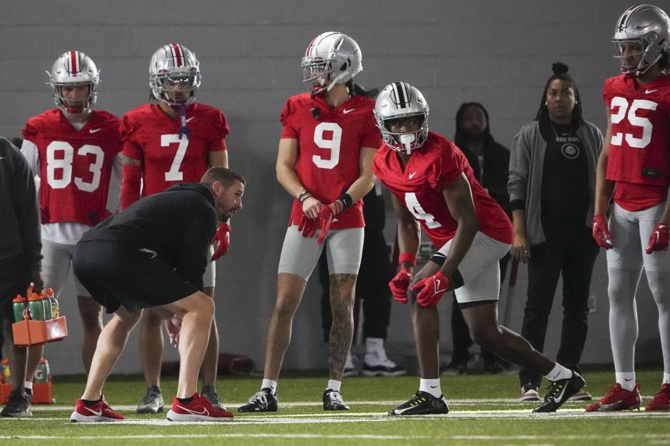 Ohio State receivers coach Brian Hartline lines up beside freshman Jeremiah Smith (4) during practice.