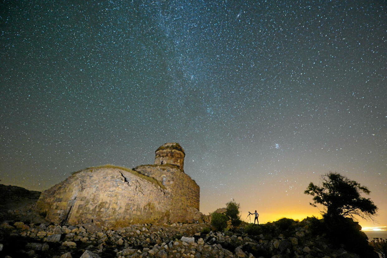 Un photographe surveille le passage des météores perséides près du monastère de Saint-Thomas dans le village d'Altinsac, en Turquie, en août 2018.  - Credit:Ozkan Bilgin/Anadolu Agency via AFP