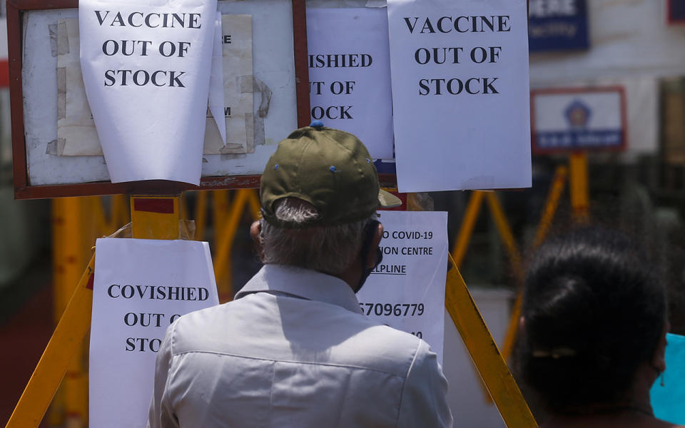 A man in a cap stares at signs saying the vaccine is out of stock at an Indian vaccination centre.
