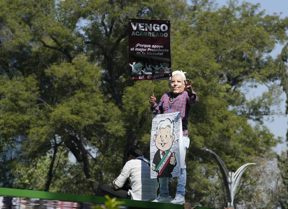 A man wears a mask with the image of Mexican President Andres Manuel Lopez Obrador during a march in support of his administration, in Mexico City, Sunday, Nov. 27, 2022.(AP Photo/Fernando Llano)