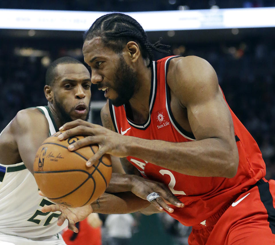 Toronto Raptors' Kawhi Leonard, right, drives to the basket against Milwaukee Bucks' Khris Middleton during the first half of an NBA basketball game, Saturday, Jan. 5, 2019, in Milwaukee. (AP Photo/Aaron Gash)