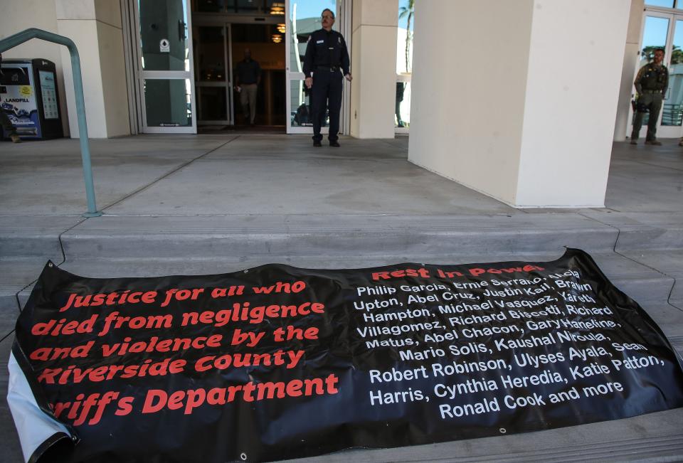 A banner with the names of those people who have died while in the custody of the Riverside County Sheriff's Department sits Tuesday on the steps of the County Administrative Center in Riverside.