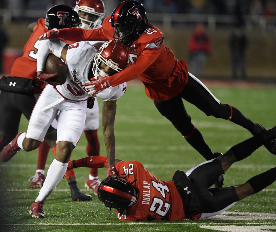 Texas Tech defensive backs Dadrion Taylor-Demerson, top right, and Malik Dunlap tackle Oklahoma's Jalil Farooq last season. That pair helps give the Red Raiders one of the more experienced secondaries in the Big 12.
