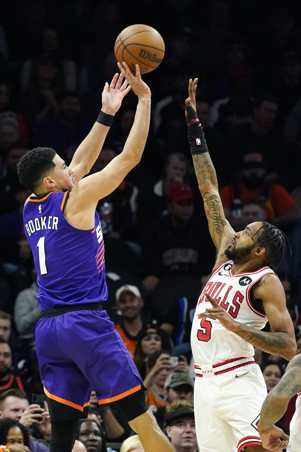 Phoenix Suns guard Devin Booker (1) shoots over Chicago Bulls forward Derrick Jones Jr. (5) during the second half of an NBA basketball game in Phoenix, Wednesday, Nov. 30, 2022. The Suns won 132-113. (AP Photo/Ross D. Franklin)