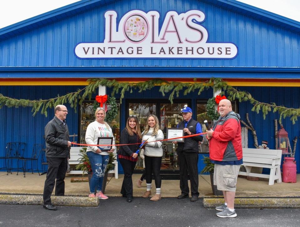 The Port Clinton Area Chamber of Commerce hosted a ribbon cutting at Lola’s Vintage Lakehouse on Dec. 16. Standing with the ribbon are, left to right, Ottawa County Commissioner Mark Coppeler, Chamber Board Member Amber Schierberg, Lola’s co-owner Lisa Smith, Lola’s co-owner Chastity Shank, Kim Smith and Port Clinton Mayor Mike Snider.