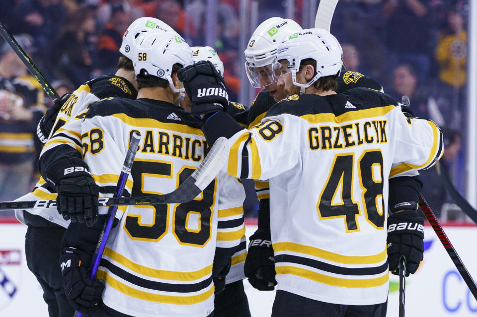 Boston Bruins' Charlie Coyle, second from right, celebrates his goal with teammates during the first period of an NHL hockey game against the Philadelphia Flyers, Sunday, April 9, 2023, in Philadelphia. (AP Photo/Chris Szagola)