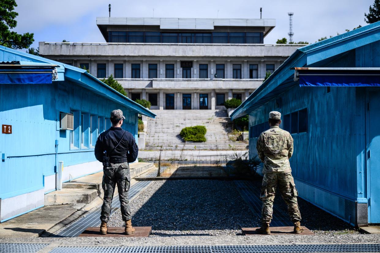 Two soldiers stand guard at the military demarcation line separating North and South Korea inside the Demilitarized Zone.