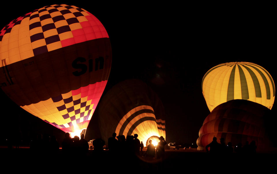 FILE - In this Friday, Nov. 23, 2012 file photo, tourists wait their turns to ascend in hot air balloons before sunrise in Luxor, Egypt. A hot air balloon flying over Egypt's ancient city of Luxor caught fire and crashed into a sugar cane field outside al-Dhabaa village, just west of the city of Luxor,  Egypt, Tuesday, Feb. 26, 2013, killing at least 18 foreign tourists, a security official said. Hot air ballooning, usually at sunrise over the famed Karnak and Luxor temples as well as the Valley of the Kings, is a popular pastime for tourists visiting Luxor. (AP Photo/Nariman El-Mofty, File)