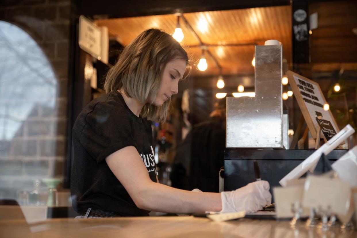 Worker seen checking the cash register before mandatory close at Warehouse 4 Coffee Shop on March 15, 2020 in Vandalia, Ohio. - Ohio Governor Mike DeWine made it mandatory to shutdown all bars and restaurants starting at 9pm tonight in the state. (Photo by Brad LEE / AFP) (Photo by BRAD LEE/AFP via Getty Images)