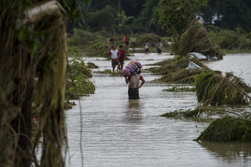 <p>Residents walk on road submerged by flood waters from Swar Chaung Dam in Swar township in Bago region in Myanmar on Aug. 30, 2018. (Photo: Ye Aung Thu/AFP/Getty Images) </p>