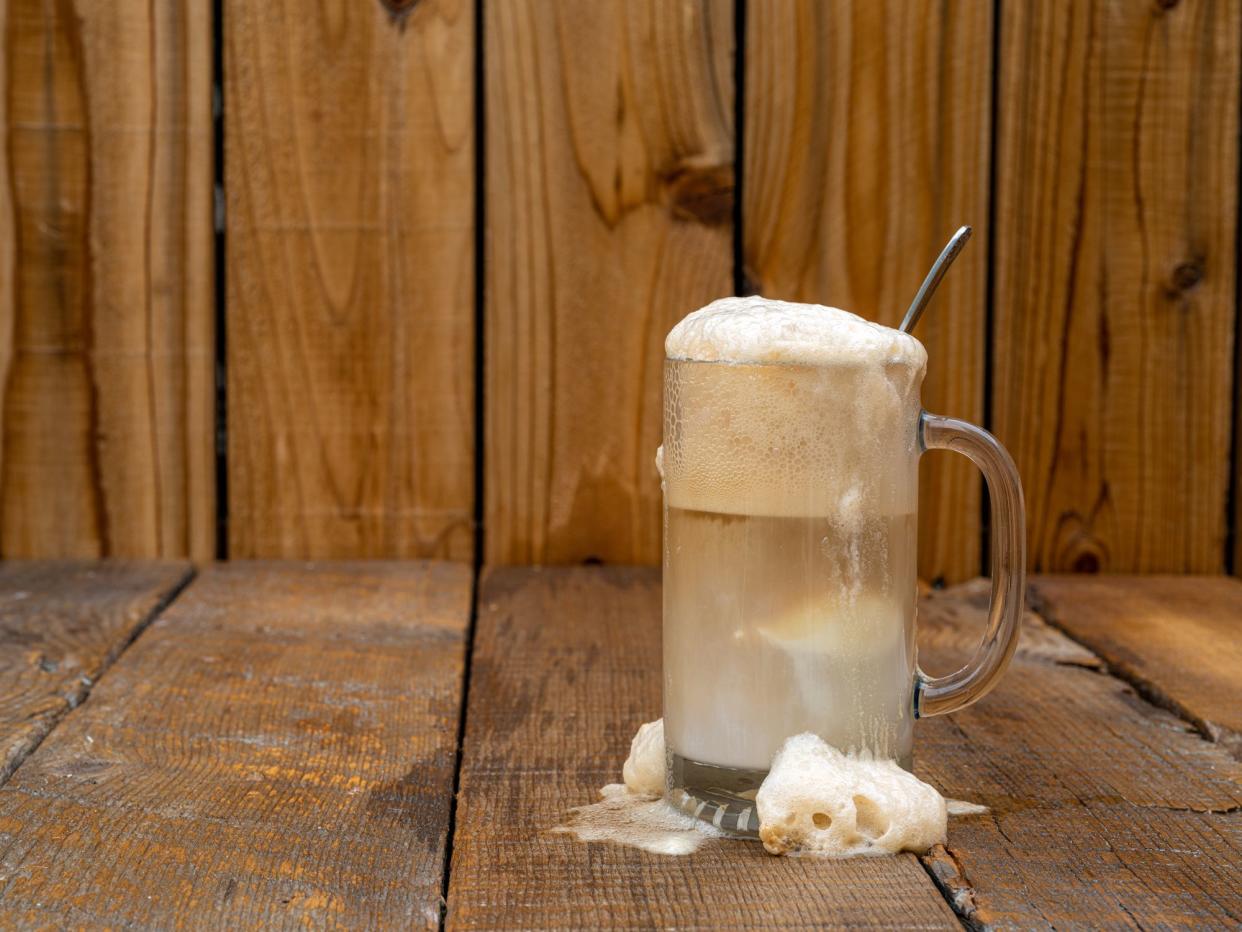 Old Fashioned Frothy Root Beer ice cream float on a rustic wooden background with copy space.