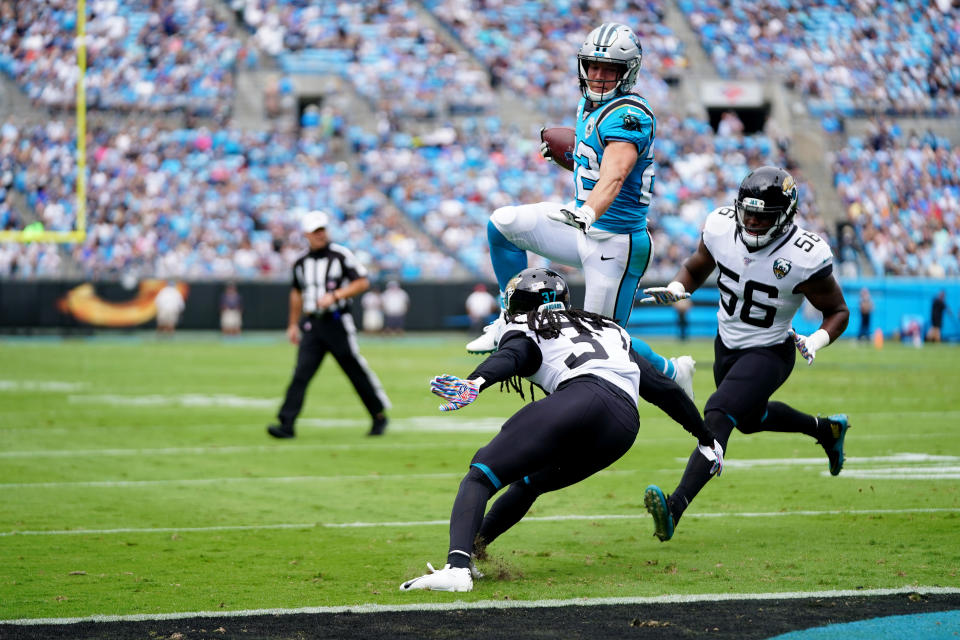 CHARLOTTE, NORTH CAROLINA - OCTOBER 06: Christian McCaffrey #22 of the Carolina Panthers scores a touchdown by leaping over Tre Herndon #37 of the Jacksonville Jaguars in the first quarter during their game at Bank of America Stadium on October 06, 2019 in Charlotte, North Carolina. (Photo by Jacob Kupferman/Getty Images)