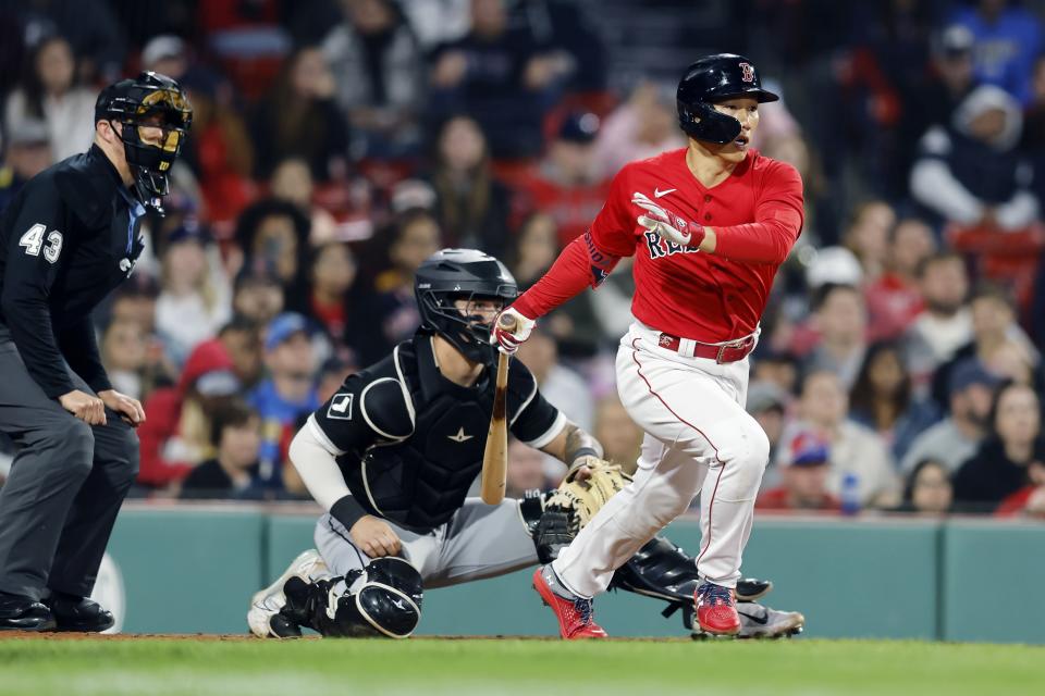 Boston Red Sox's Masataka Yoshida, right, follows through on his RBI single in front of Chicago White Sox catcher Korey Lee during the eighth inning of a baseball game, Friday, Sept. 22, 2023, in Boston. (AP Photo/Michael Dwyer)