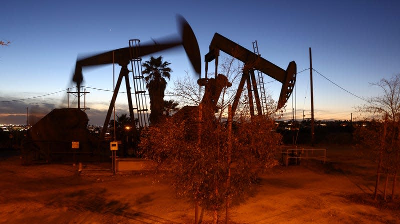 Two oil pumpjacks are shown in motion