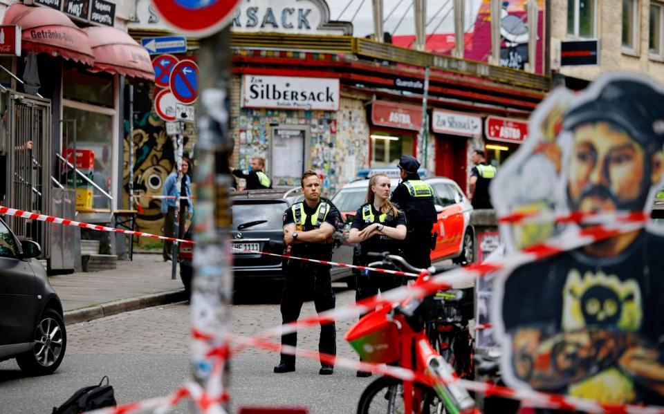 Police officers guard a cordoned off area on Silbersackstrasse after an attacker was shot down by police officers in the St. Pauli district of Hamburg