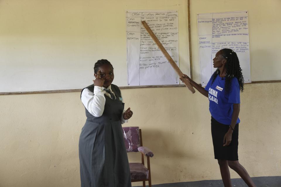 Elizabeth Motale, right, a climate agriculture expert, points in class during a climate change lesson, as Bridget Chanda serves as a sign language interpreter at Chileshe Chepela Special School in Kasama, Zambia, Wednesday, March 6, 2024. Chanda is intent on helping educate Zambia's deaf community about climate change. As the southern African nation has suffered from more frequent extreme weather, including its current severe drought, it's prompted the Zambian government to include more climate change education in its school curriculum. (AP Photo/Tsvangirayi Mukwazhi)