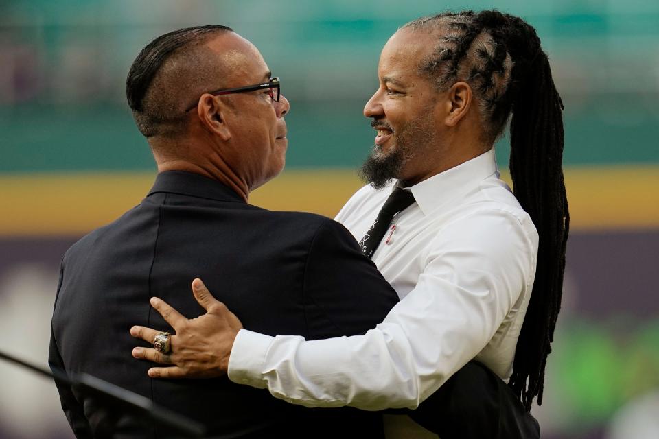 Former Cleveland baseball player Manny Ramirez, right, is embraced by former teammate Carlos Baerga, left, during induction ceremonies into the Cleveland Guardians Hall of Game before a game Saturday between the Detroit Tigers and the Guardians in Cleveland.