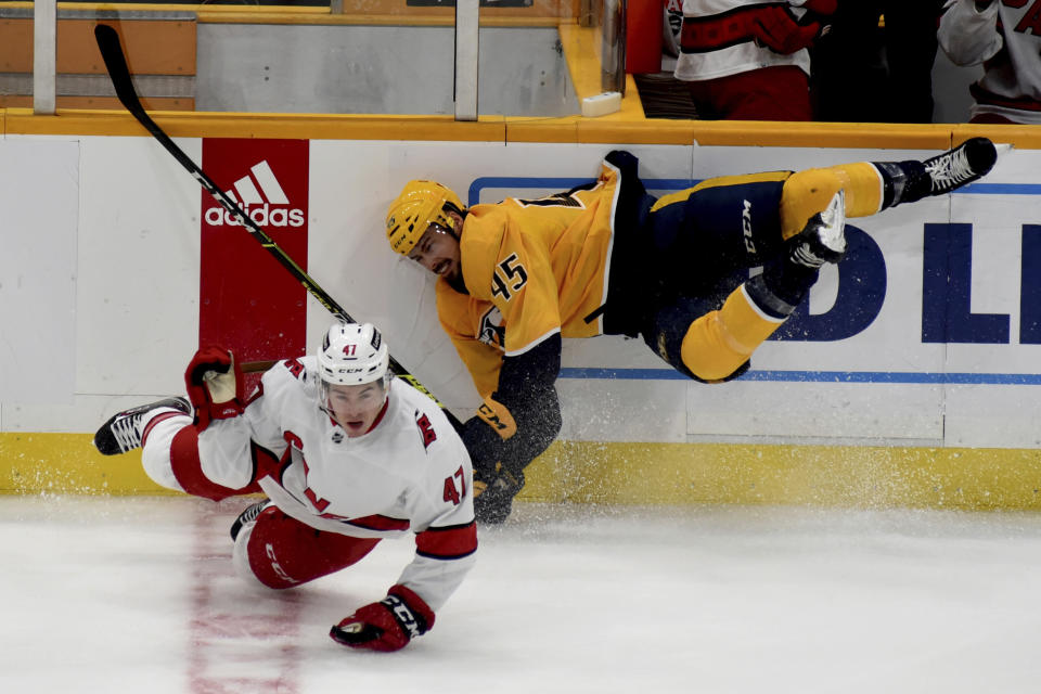 Carolina Hurricanes left wing C.J. Smith (47) and Nashville Predators defenseman Alexandre Carrier (45) collide in the second period of a preseason NHL hockey game Saturday, Oct. 9, 2021, in Nashville, Tenn. (AP Photo/Mike Strasinger)