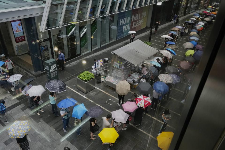 People queue up for last issue of Apple Daily at a newspaper booth at a downtown street in Hong Kong, Thursday, June 24, 2021. Hong Kong's sole remaining pro-democracy newspaper has published its last edition. Apple Daily was forced to shut down Thursday after five editors and executives were arrested and millions of dollars in its assets were frozen as part of China's increasing crackdown on dissent in the semi-autonomous city. (AP Photo/Vincent Yu)