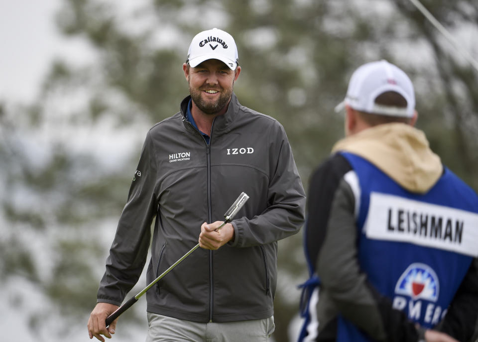 Marc Leishman, of Australia, smiles after putting on the fourth hole of the South Course at Torrey Pines Golf Course during the final round of the Farmers Insurance golf tournament Sunday, Jan. 26, 2020, in San Diego. (AP Photo/Denis Poroy)