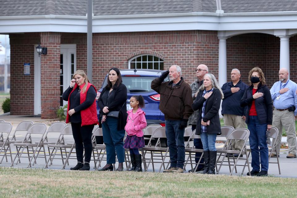 Rhonda Schur, left, daughter of Navy veteran Steven Walle, wipes her eye during the playing of the National Anthem during a dedication ceremony  Tuesday afternoon, Nov. 10, 2021, at Hospice House. Her family is a fourth-generation military family and Schur, who works as the Hospice House Coordinator, said that the family wanted to show its appreciation to the Hospice House for their great care of Walle, who died Jan. 1, 2021. The family donated the flagpole in honor of all who have served and in memory of their hero, Steven Walle.